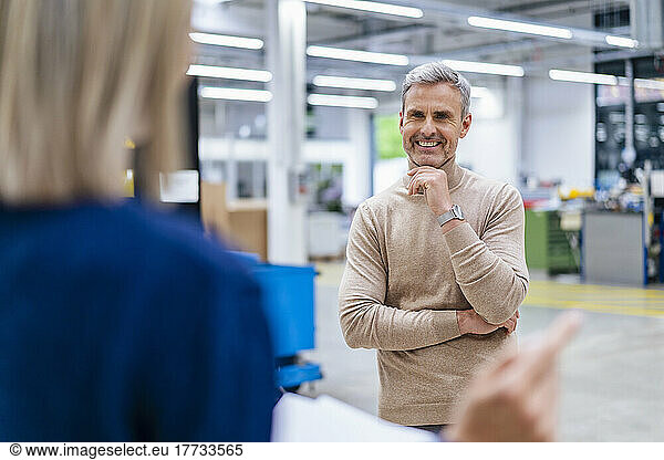 Businessman smiling at colleague in factory