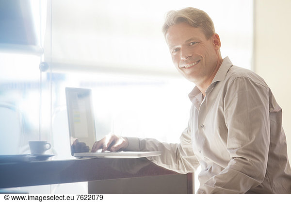 Businessman smiling at laptop
