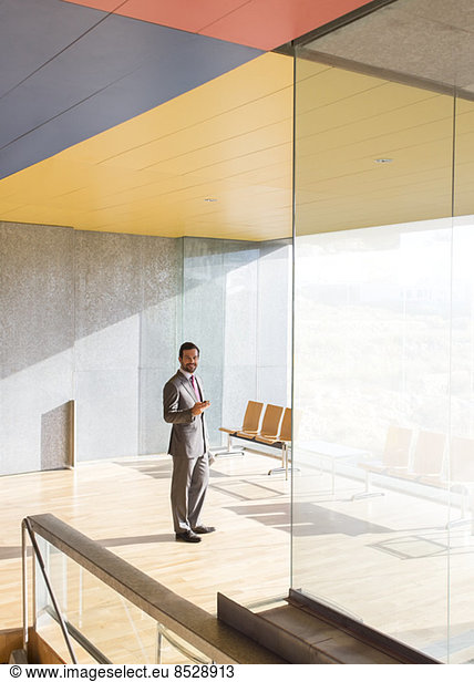 Businessman smiling in sunny office lobby