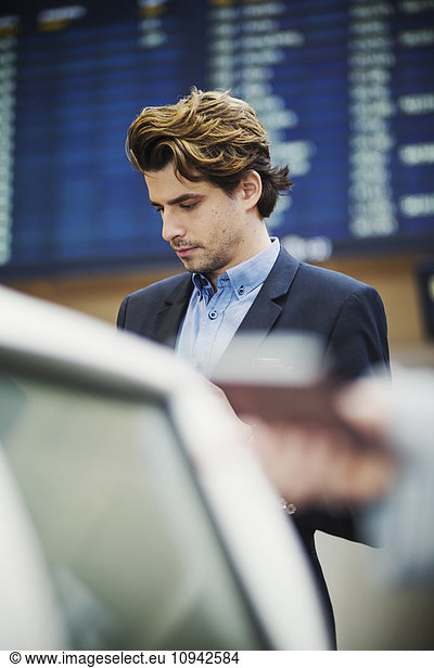 Businessman standing at airport check-in counter