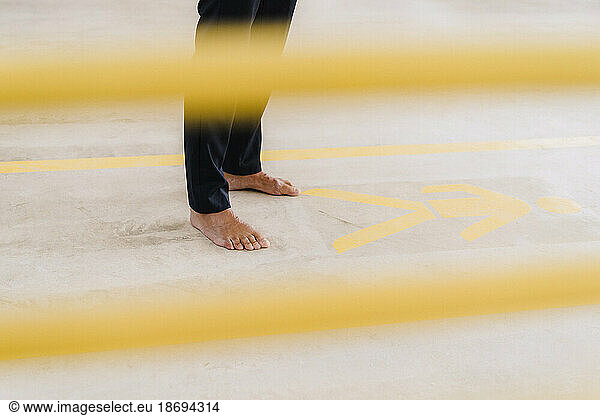 Businessman standing barefoot on floor in factory