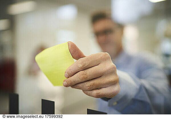 Businessman taking adhesive note in office