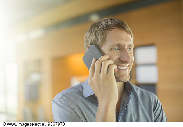 Businessman talking on cell phone in office