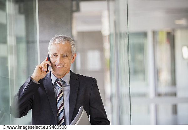 Businessman talking on cell phone in office building
