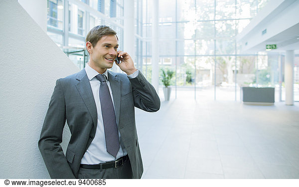 Businessman talking on cell phone in office building