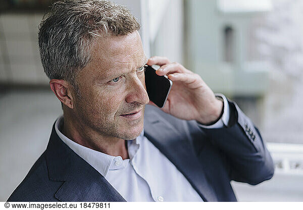 Businessman talking on smart phone in cafe