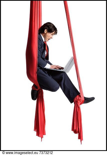 Businessman tangled in red drapes