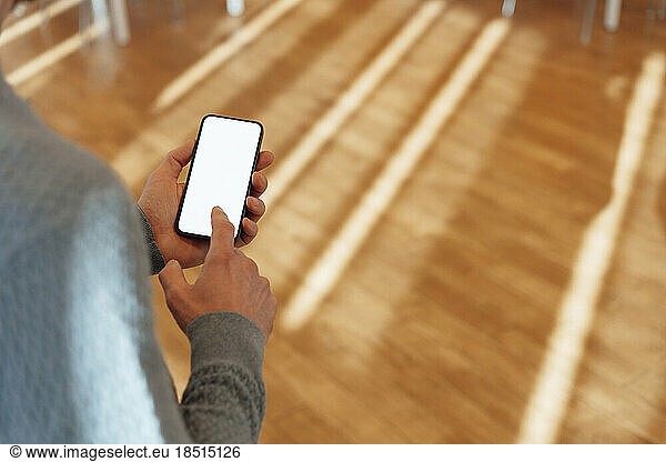 Businessman touching screen of smart phone in office