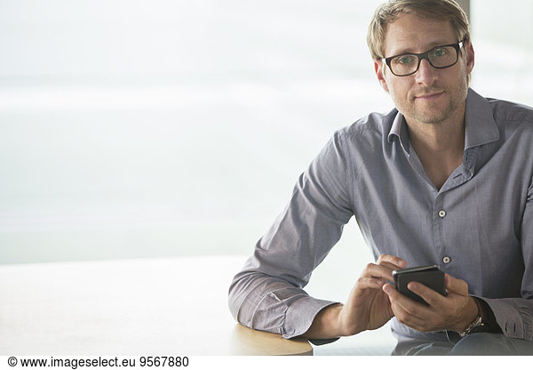 Businessman using cell phone at table