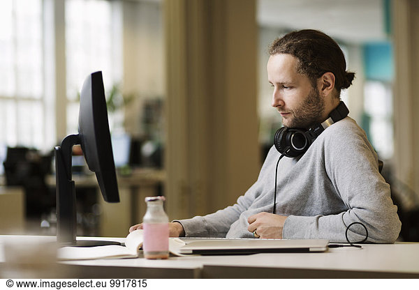 Businessman using desktop PC in creative office