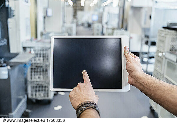 Businessman using digital tablet in factory