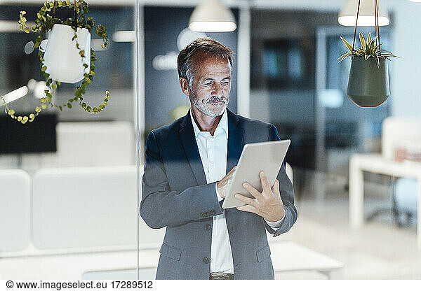 Businessman using digital tablet while working in office