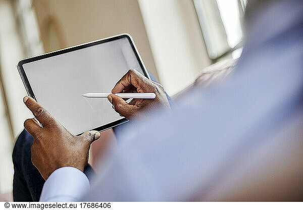 Businessman using digitized pen on tablet computer at home