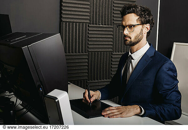 Businessman using graphic tablet at desk in office