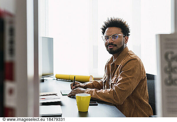 Businessman using graphics tablet sitting at desk