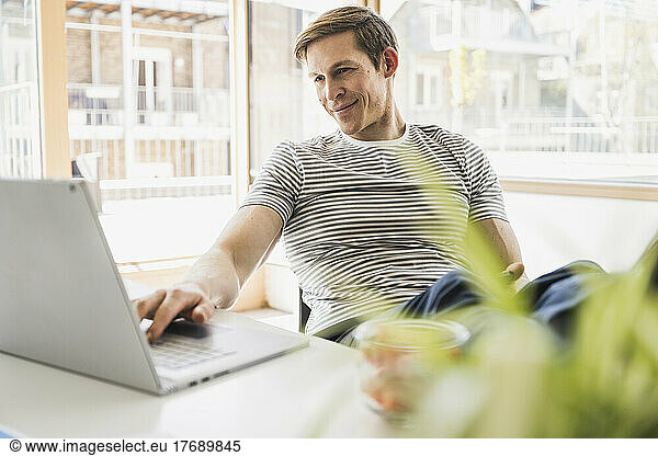 Businessman using laptop at desk in office