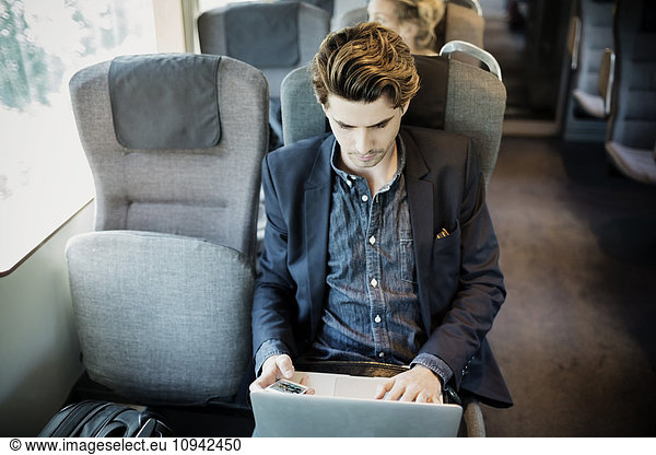 Businessman using laptop in train