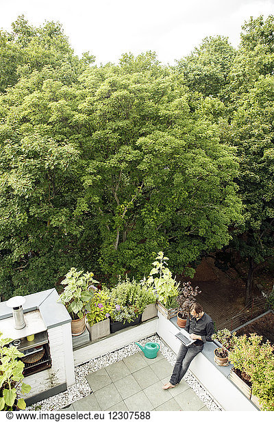 Businessman using laptop on balcony