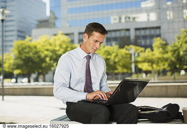 Businessman using laptop outdoors