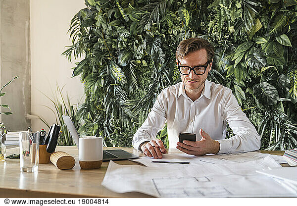 Businessman using smart phone at desk
