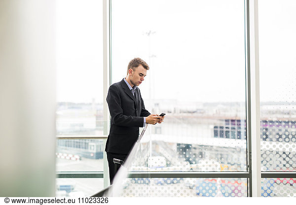 Businessman using smart phone in airport