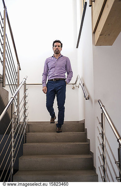 Businessman walking downstairs in staircase