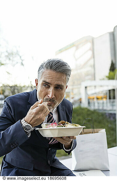 Businessman wearing suit eating lunch