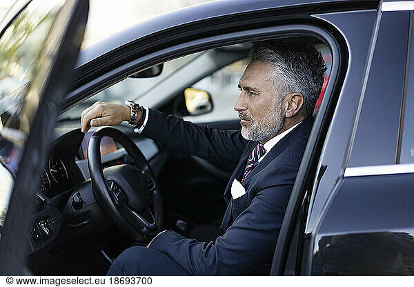 Businessman wearing suit sitting in car