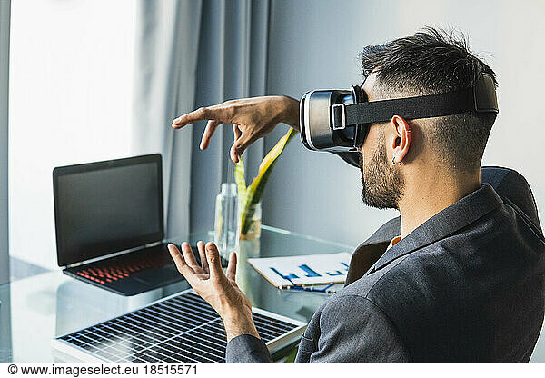 Businessman wearing virtual reality headset at home office
