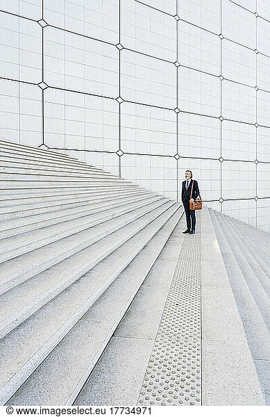 Businessman with bag standing on staircase
