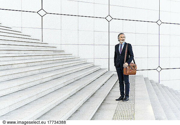 Businessman with bag standing on steps