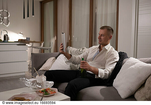 Businessman with beer making video call