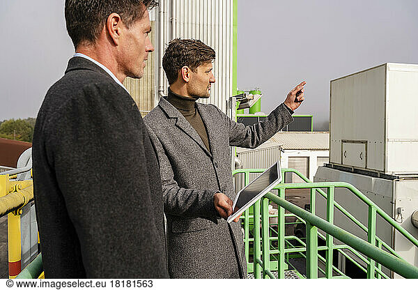 Businessman with colleague discussing at recycling center