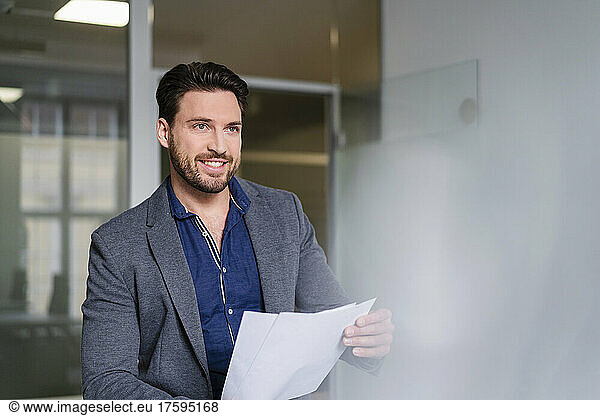 Businessman with document contemplating in office