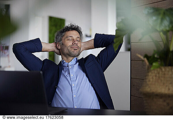 Businessman with eyes closed sitting in office