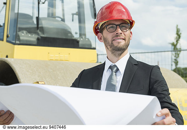 Businessman with hard hat on construction site