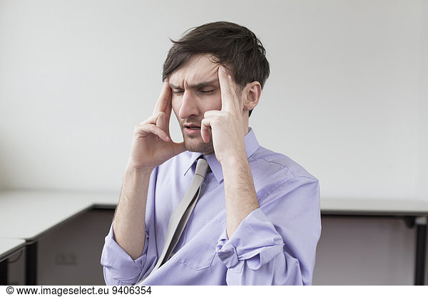 Businessman with headache in office