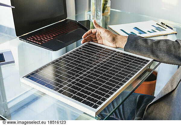 Businessman with solar panel at desk in home office