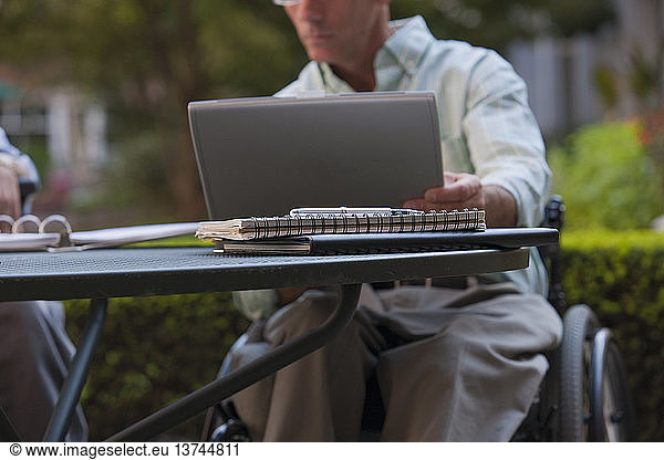 Businessman with spinal cord injury working on a laptop