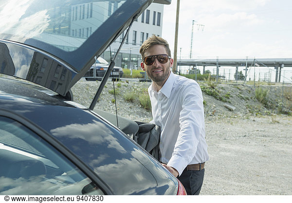 businessman with sunglasses at his car
