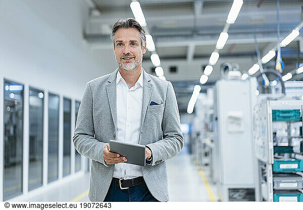 Businessman with tablet in a modern factory