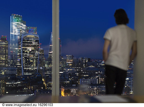 Businessman working late at highrise office window  London  UK