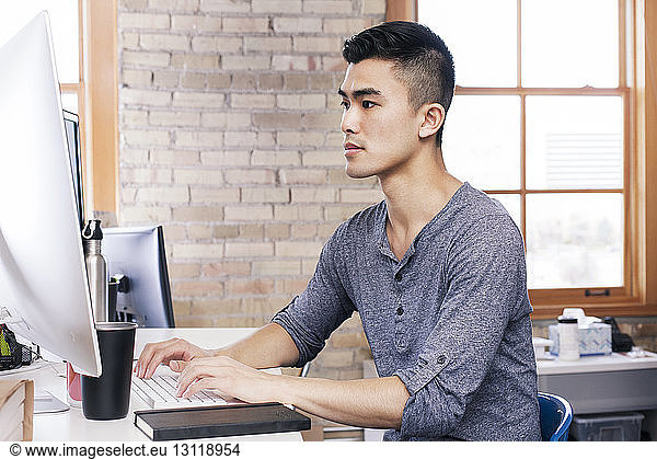 Businessman working on desktop computer in office