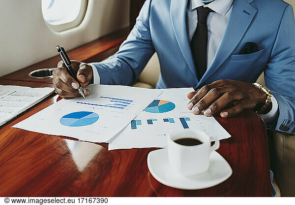 Businessman working on document in private jet