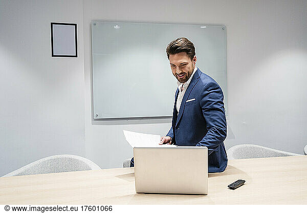 Businessman working on laptop in board room at office