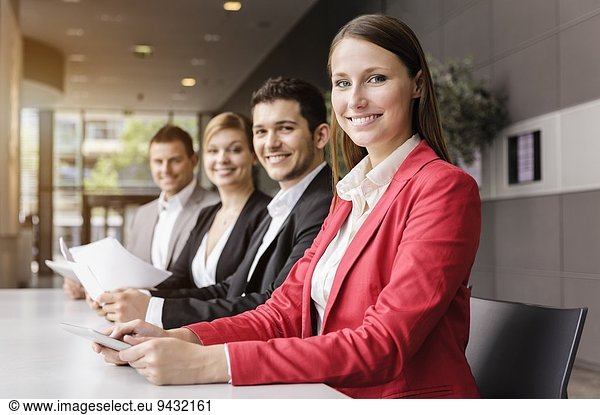 Businessmen and businesswomen with digital tablet at meeting table