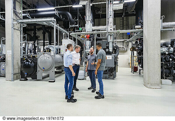 Businessmen and employees having a meeting in factory