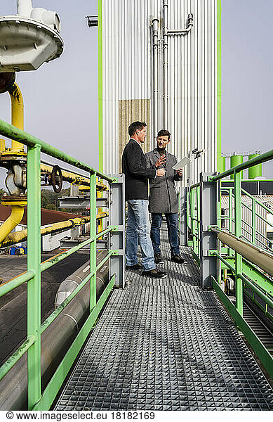 Businessmen discussing together at recycling plant
