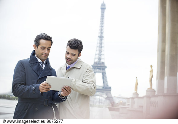 Businessmen using digital tablet near Eiffel Tower  Paris  France