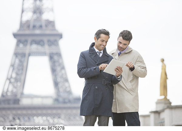 Businessmen using digital tablet near Eiffel Tower  Paris  France